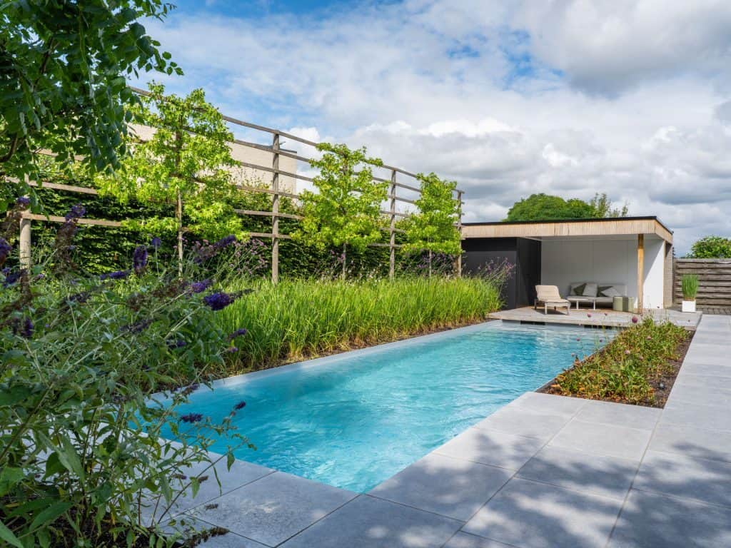 Zwemzwembad met tuin en loungeset in een moderne achtertuin.